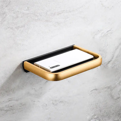 Modern black and gold tissue paper holder with phone tray featuring a sleek wall-mounted soap dish design