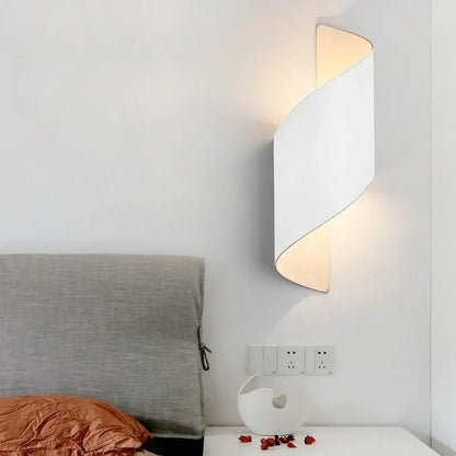 Modern black and gold twisted led wall lamp with sleek curved design emitting warm light for corridor use