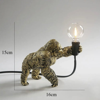 Modern black gorilla night light featuring a golden resin figurine with textured fur holding a clear bulb for decorbites gorilla night