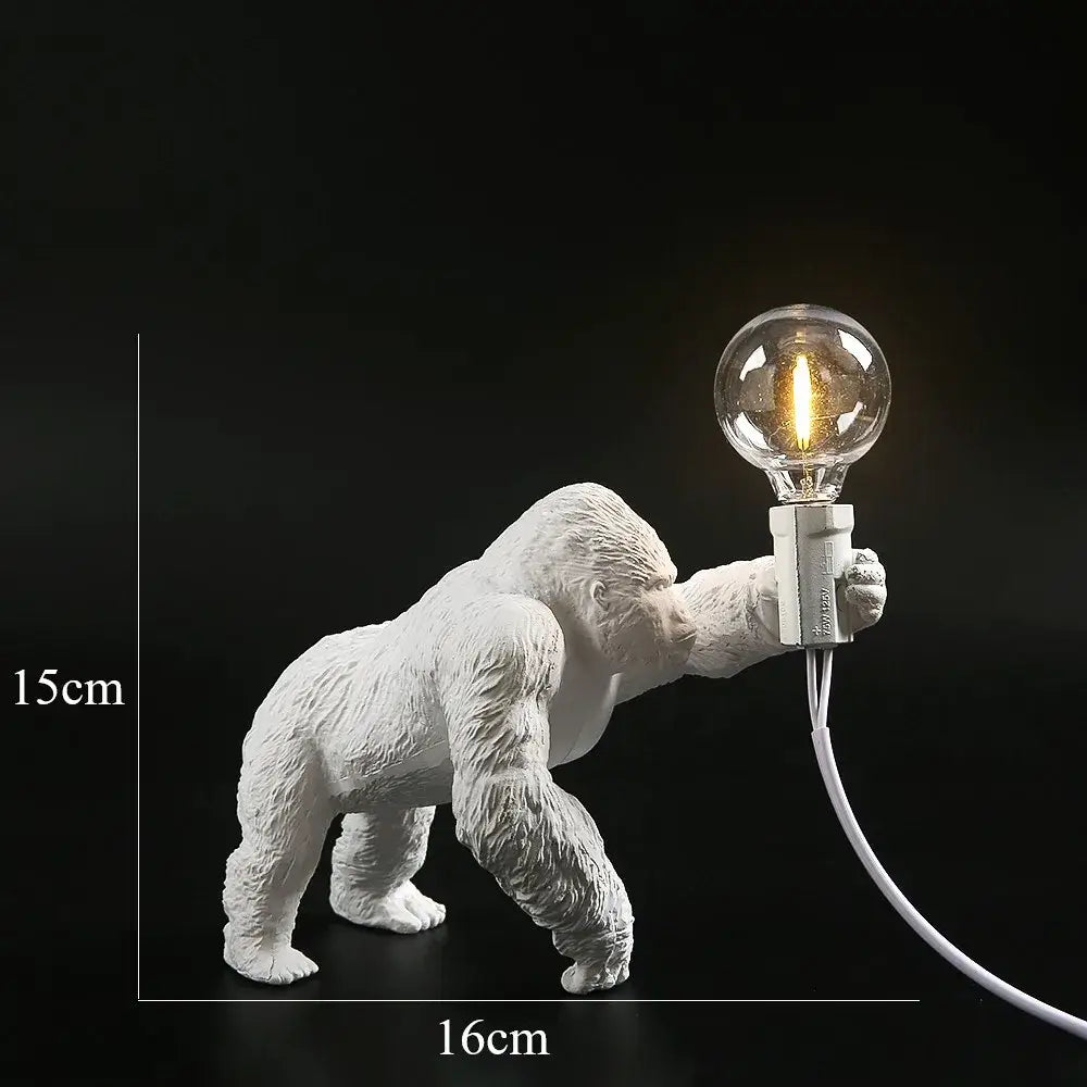 Modern black gorilla night light bedroom resin lamp featuring a white ceramic gorilla holding a glowing filament bulb