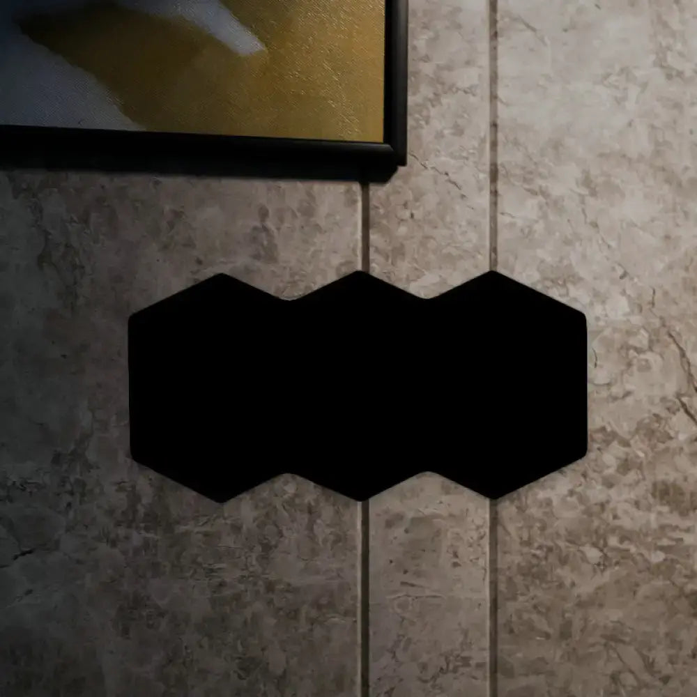 Modern black hexagon aluminum shade wall mount light with acoustic panels arranged in a continuous interlocking pattern