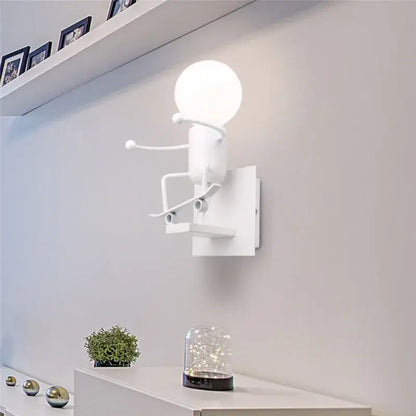 Modern black iron cartoon doll wall sconce with white minimalist spherical bulb and sculpted metal arms for kids bedroom decorbites cartoon doll wall