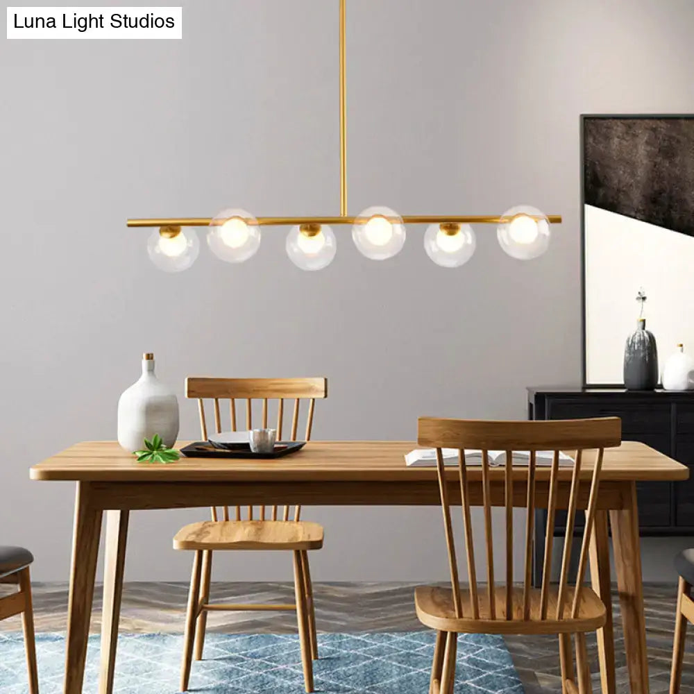 Modern black gold island pendant with clear glass globes and five gold-toned bulbs for dining room lighting