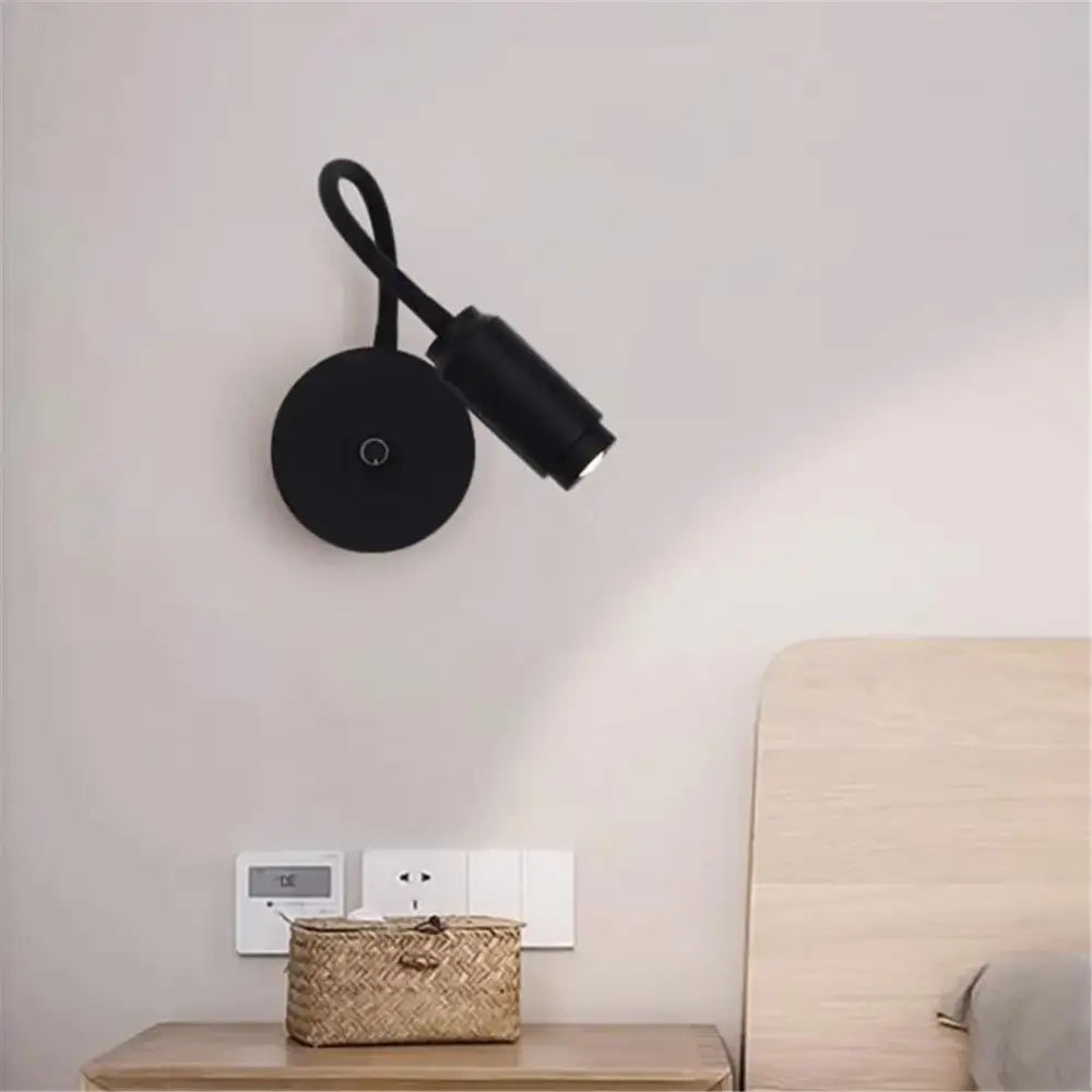 Modern black wall-mounted reading lamp with flexible gooseneck arm and black knob switch for bedroom lighting