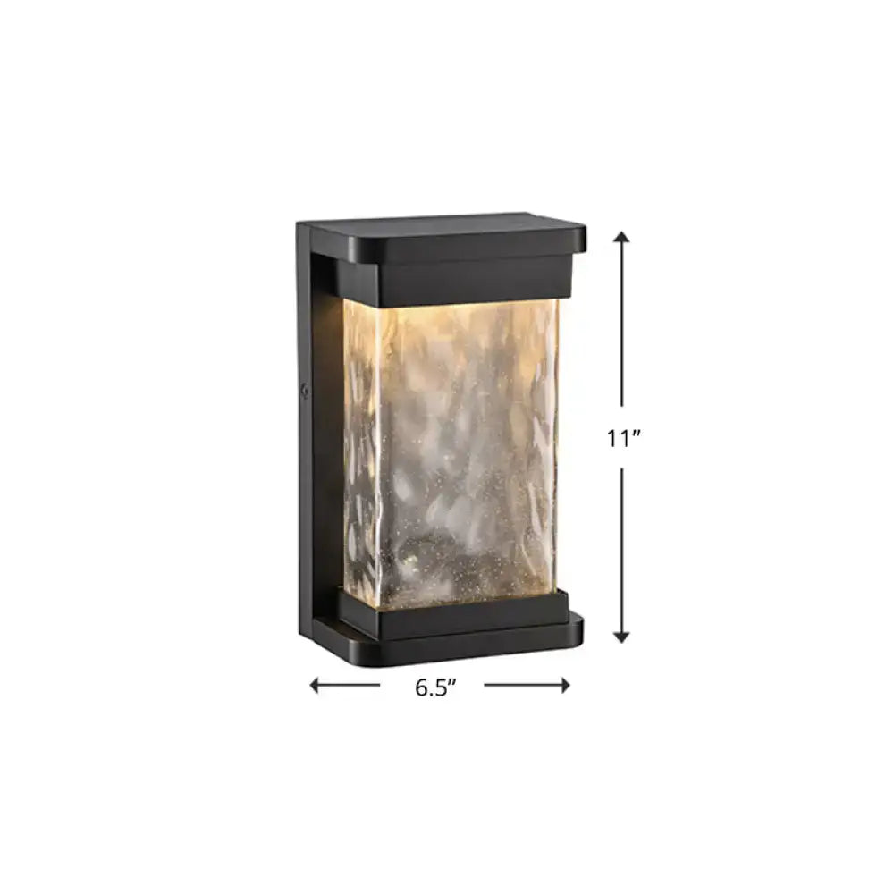 Modern black led outdoor wall sconce with textured amber-tinted rippled glass cylinder panel