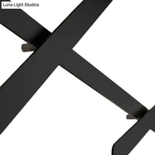 Modern black wall light with x-shaped matte metal leg and bulb included featuring a sleek bulb base design