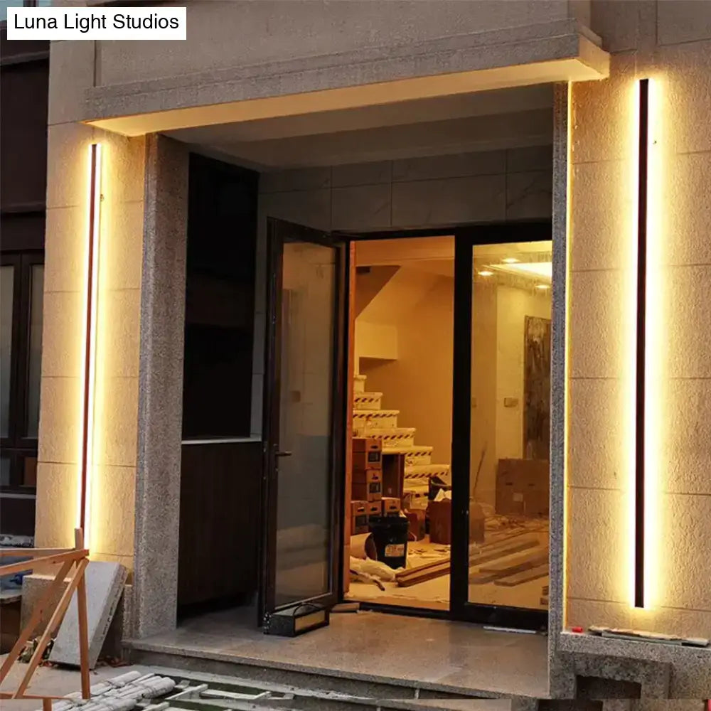 Warm vertically oriented led light strips mounted on stone pillars from DecorBites outdoor aluminium IP65 wall lamp