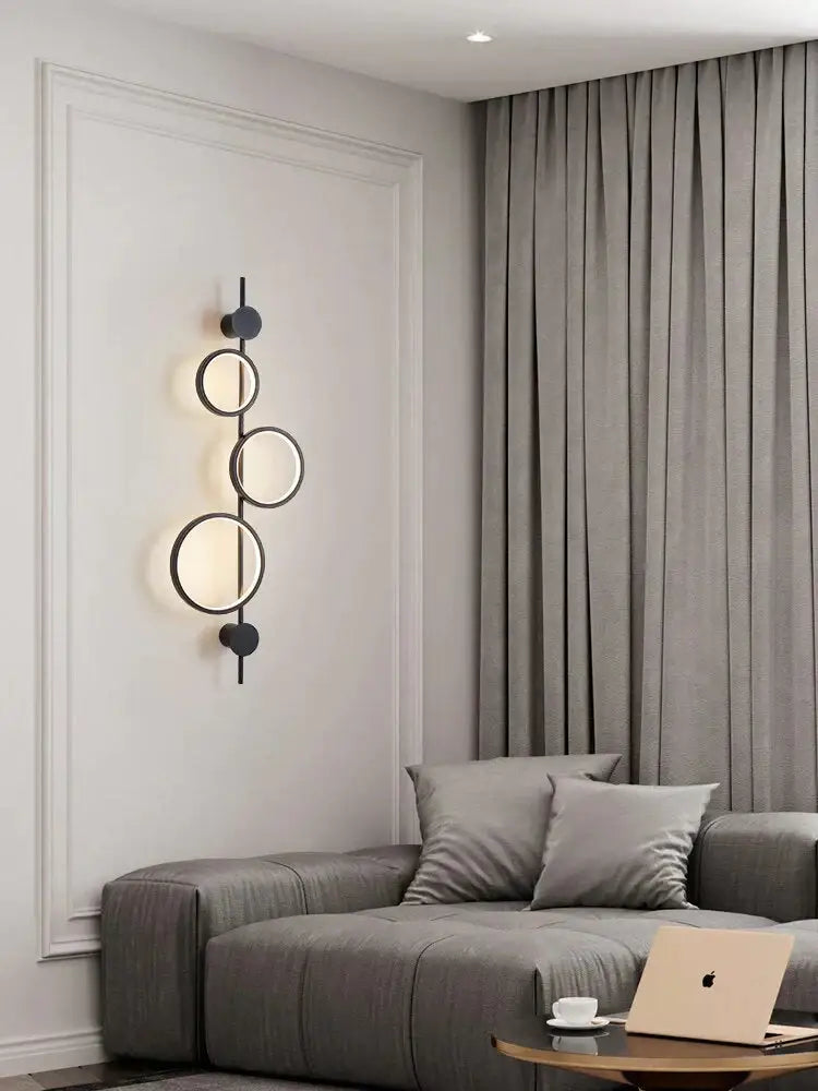 Modern black linear long led wall light featuring a circular wall sconce with three illuminated rings for living room use