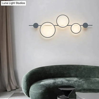 Modern black linear long led wall light with three glowing circular lights and matte gray discs in a minimalistic design