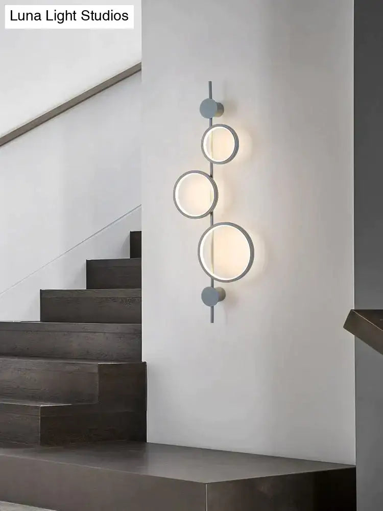 Modern black linear long led wall light with four frosted glass shades on a matte gray metal frame for living room use