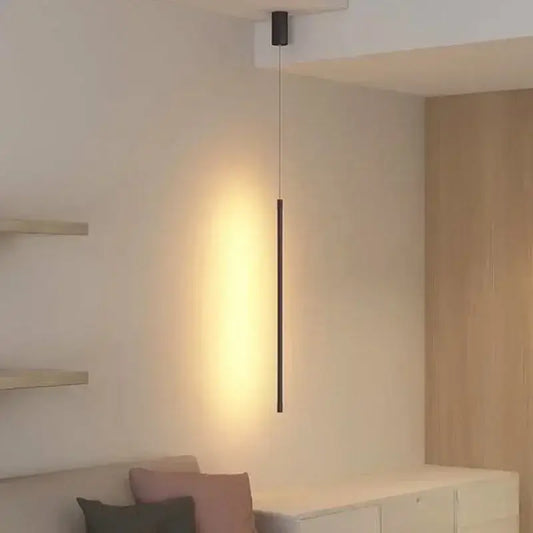 Modern black linear pendant light with a sleek cylindrical body providing warm ambient glow for dining room
