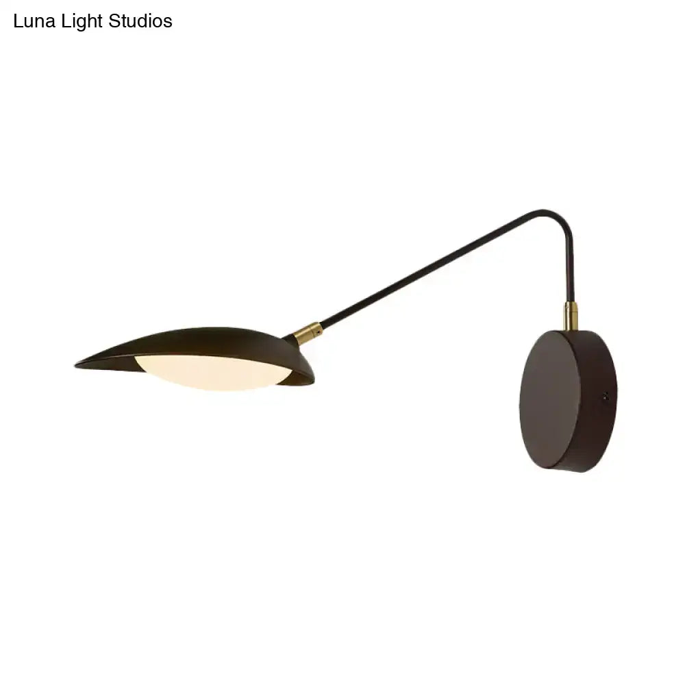 Modern black metal wall lamp with adjustable arm and gold-toned accents for bedroom reading lighting fixture