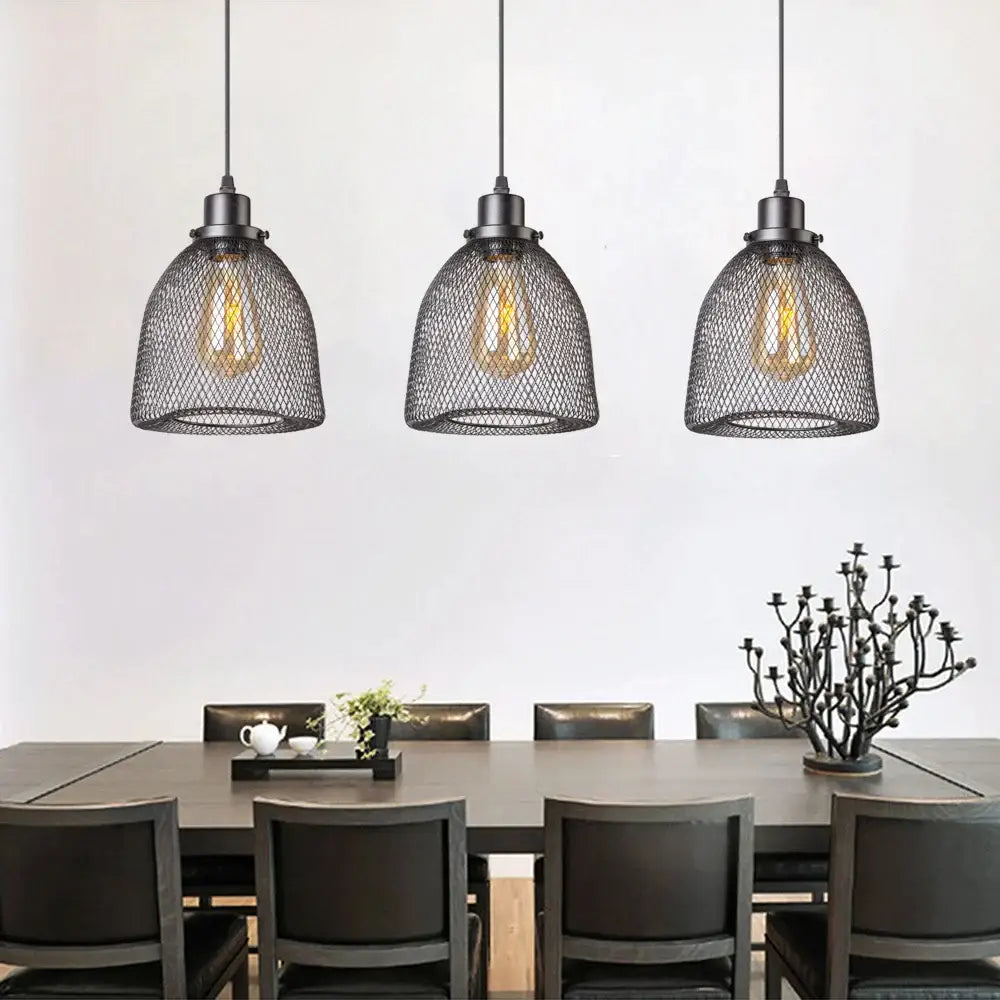 Modern black metal mesh pendant light chandelier with exposed filament bulbs hanging above dining table