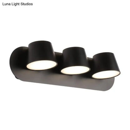 Modern black metal shade wall sconce fixture with three adjustable cylindrical lamps and compact fixture width for vanity use