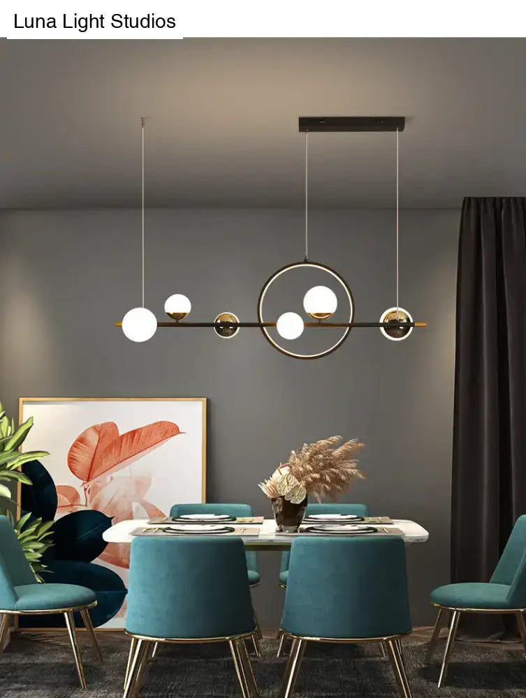 Modern black metal pendant light with spherical white glass shades suspended by cables for dining room use