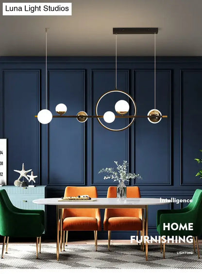 Modern black metal pendant light with sleek brass frame and white spherical glass shades for dining room use