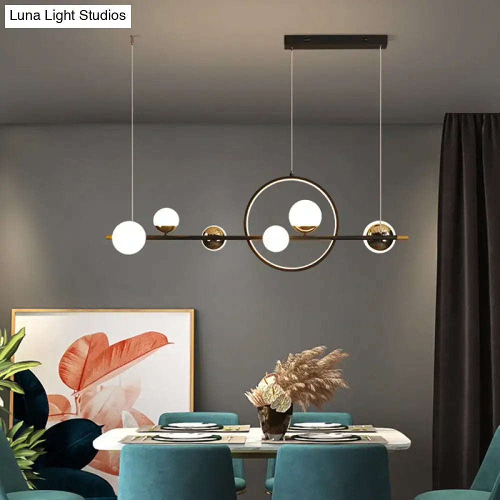 Modern black metal pendant light with spherical glass bulbs and gold-toned accents for dining room lighting