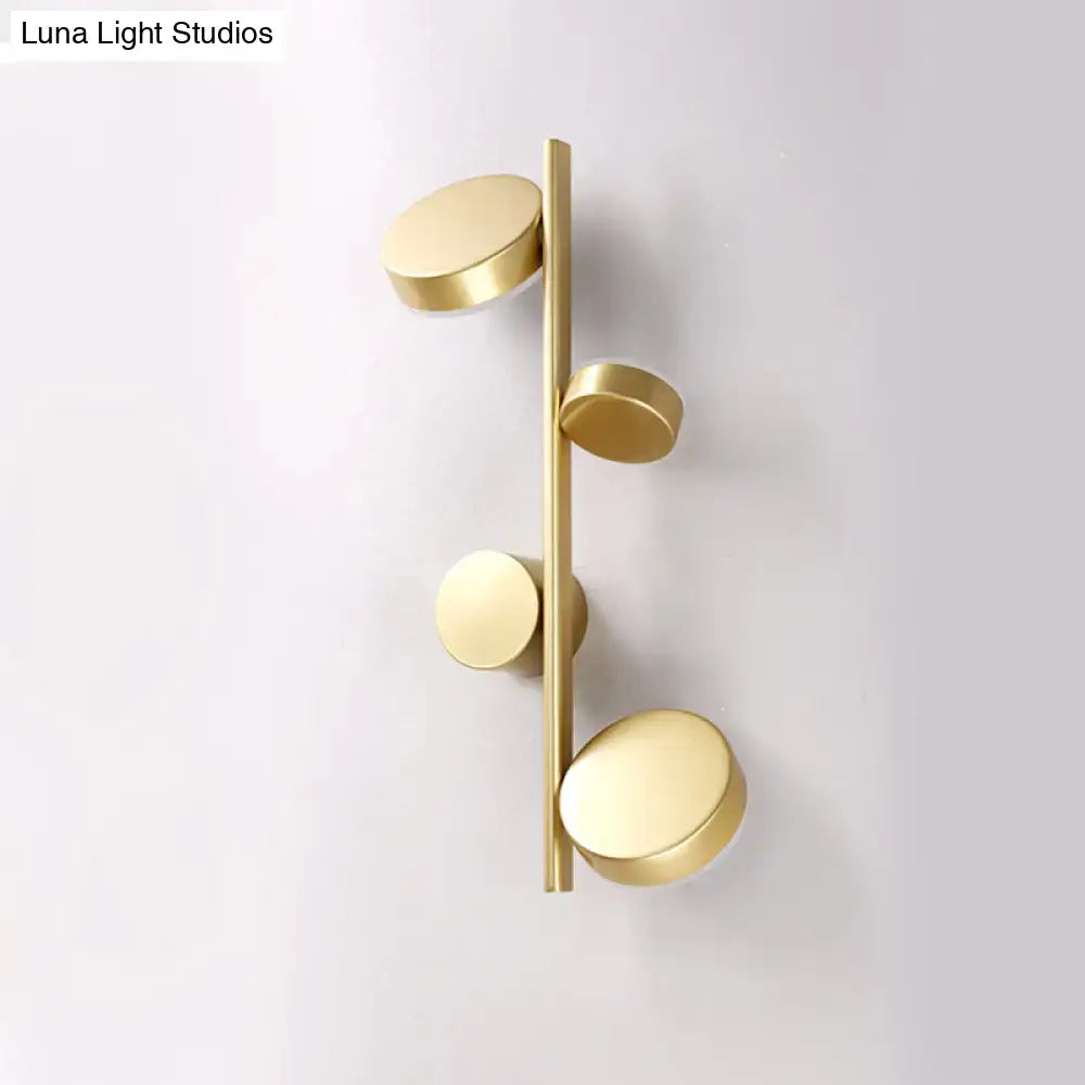 Modern brass wall sconce with four brushed gold discs on vertical bar for living room circle wall mount lighting