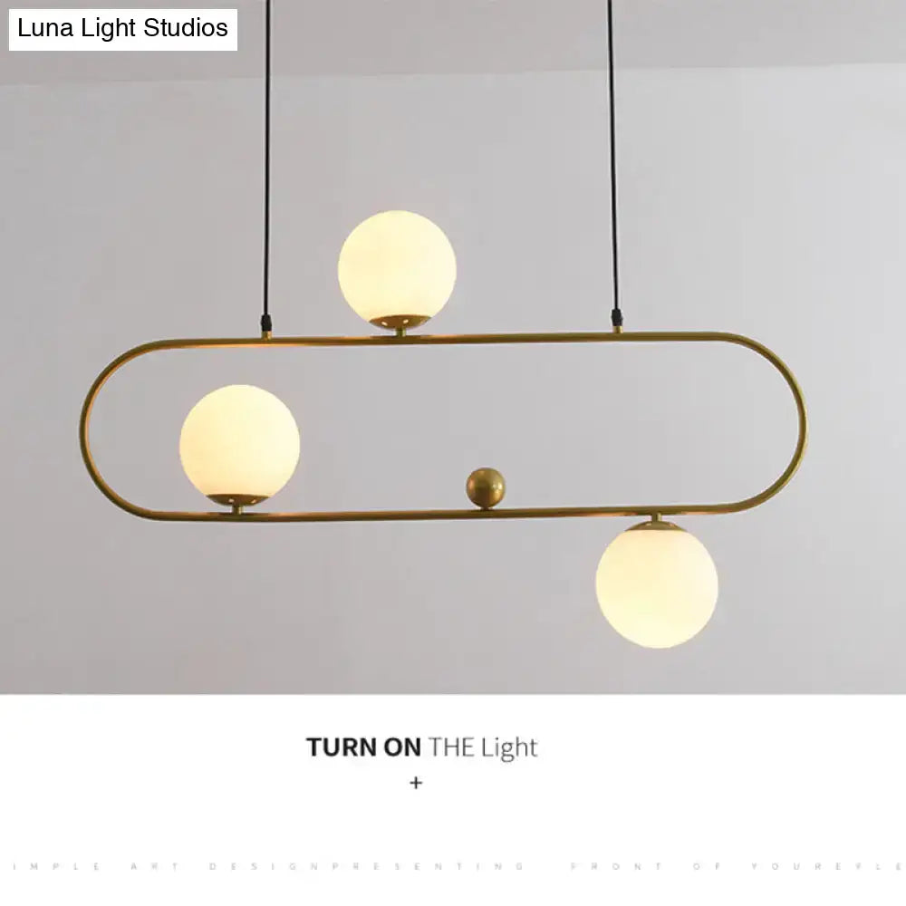 Modern brass pendant ceiling light with three frosted glass globes and black cords for minimalist ellipse living room decor