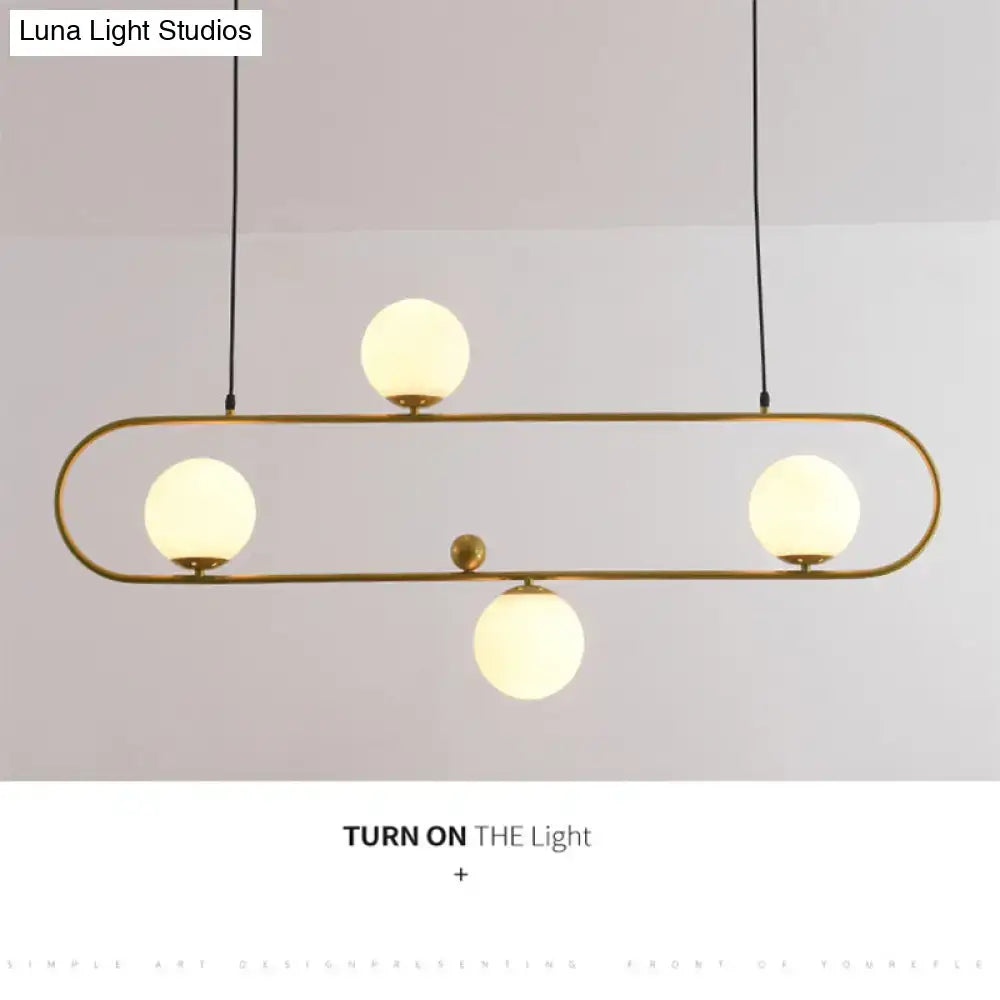 Modern brass-finished ceiling light with four frosted glass globes in a minimalist ellipse frame for living room use