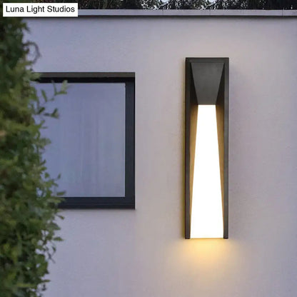 Modern black minimalist led wall light with sleek angular design emitting warm white light for courtyard use