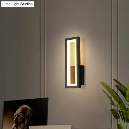 Modern black minimalist led wall sconce with a sleek rectangular design and warm lighting for foyer use