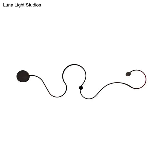 Modern black minimalist wall lamp with sleek curved lines and spherical accents emitting white light for living room use
