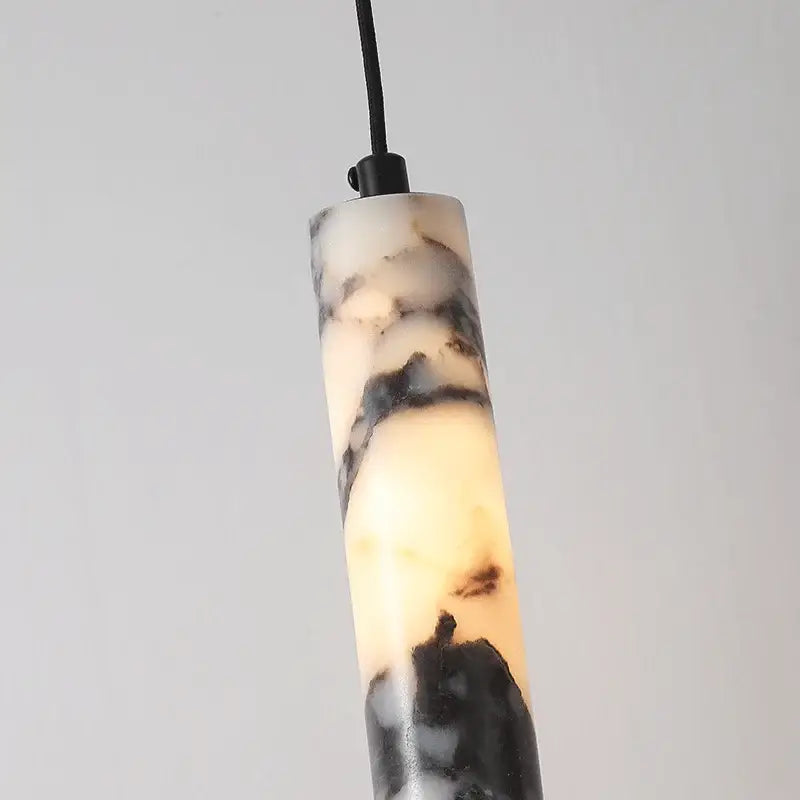 Modern black natural marble stone cylinder pendant light with polished swirling black and cream veining for kitchen