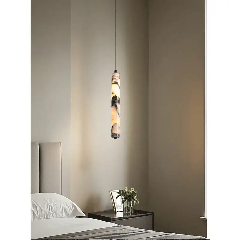Modern black natural marble stone pendant light with a warm glowing interior and layered natural stone exterior for kitchen