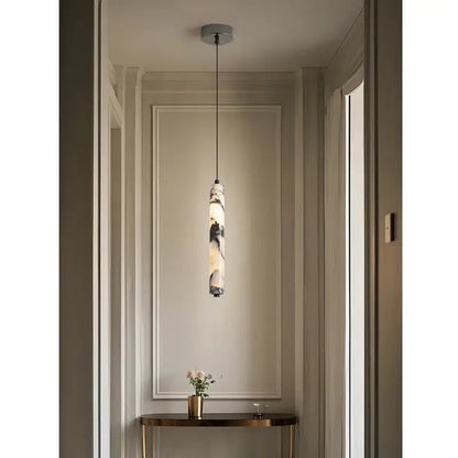 Modern black natural marble stone cylinder pendant light with a polished white and gray natural stone finish for kitchen