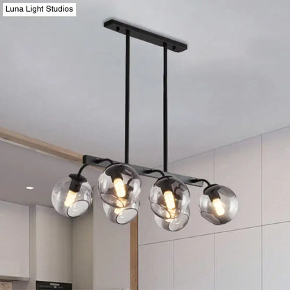 Modern black metal chandelier with four clear glass globe shades and black orb shade for kitchen and dining room lighting