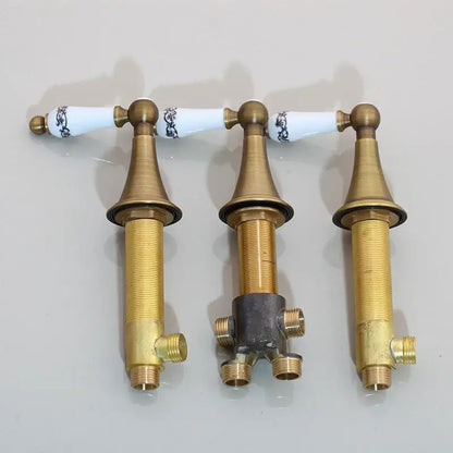 Three brass bathroom faucet handles with white ceramic knobs and blue floral patterns for black painting water control valve