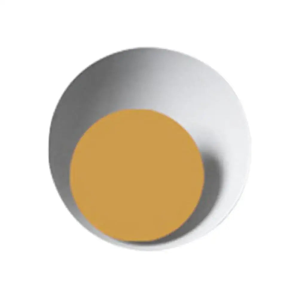 A minimalist white ceramic bowl with a glossy finish holding a golden-yellow disc for a modern circle sconce light fixture