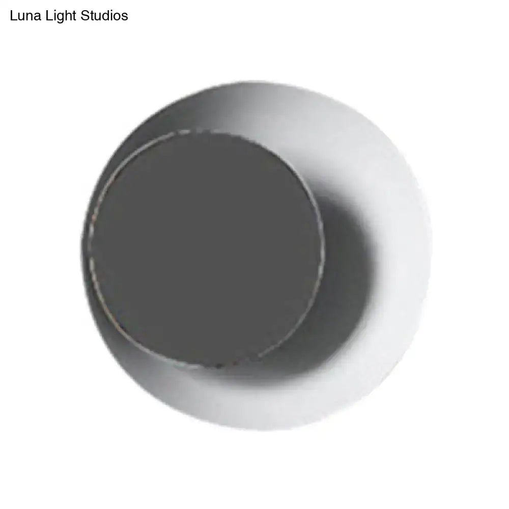 A sleek modern black and pink circle sconce light fixture with a matte dark gray inner surface and smooth white outer rim