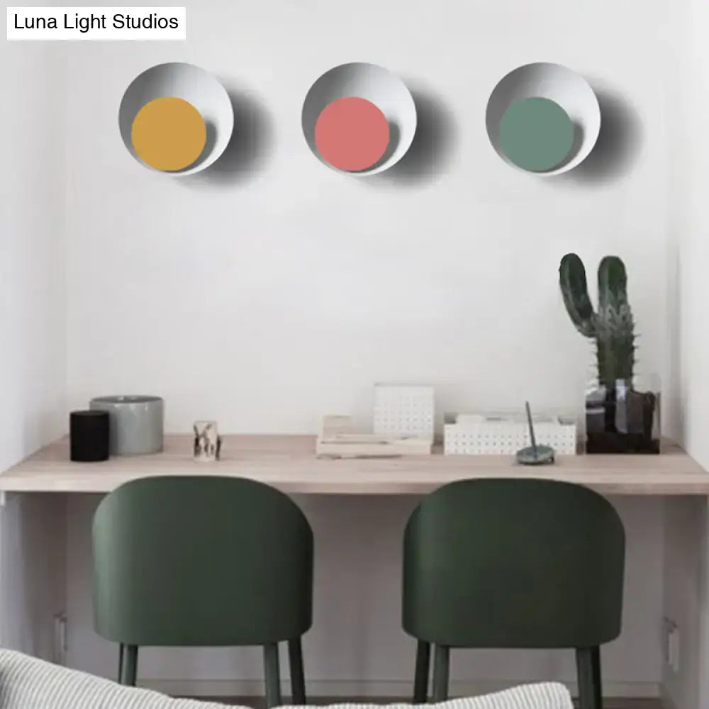 Modern black and pink circle sconce light fixture with three metallic silver framed circle sconces in yellow pink and green