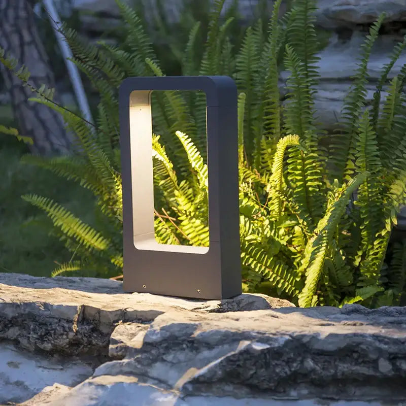 Modern black rectangular outdoor led lawn light with a glowing light panel for garden and landscape lighting
