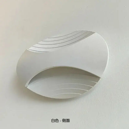 Modern white sleek curved led wall lamp with subtle linear grooves for warm amber corridor lighting