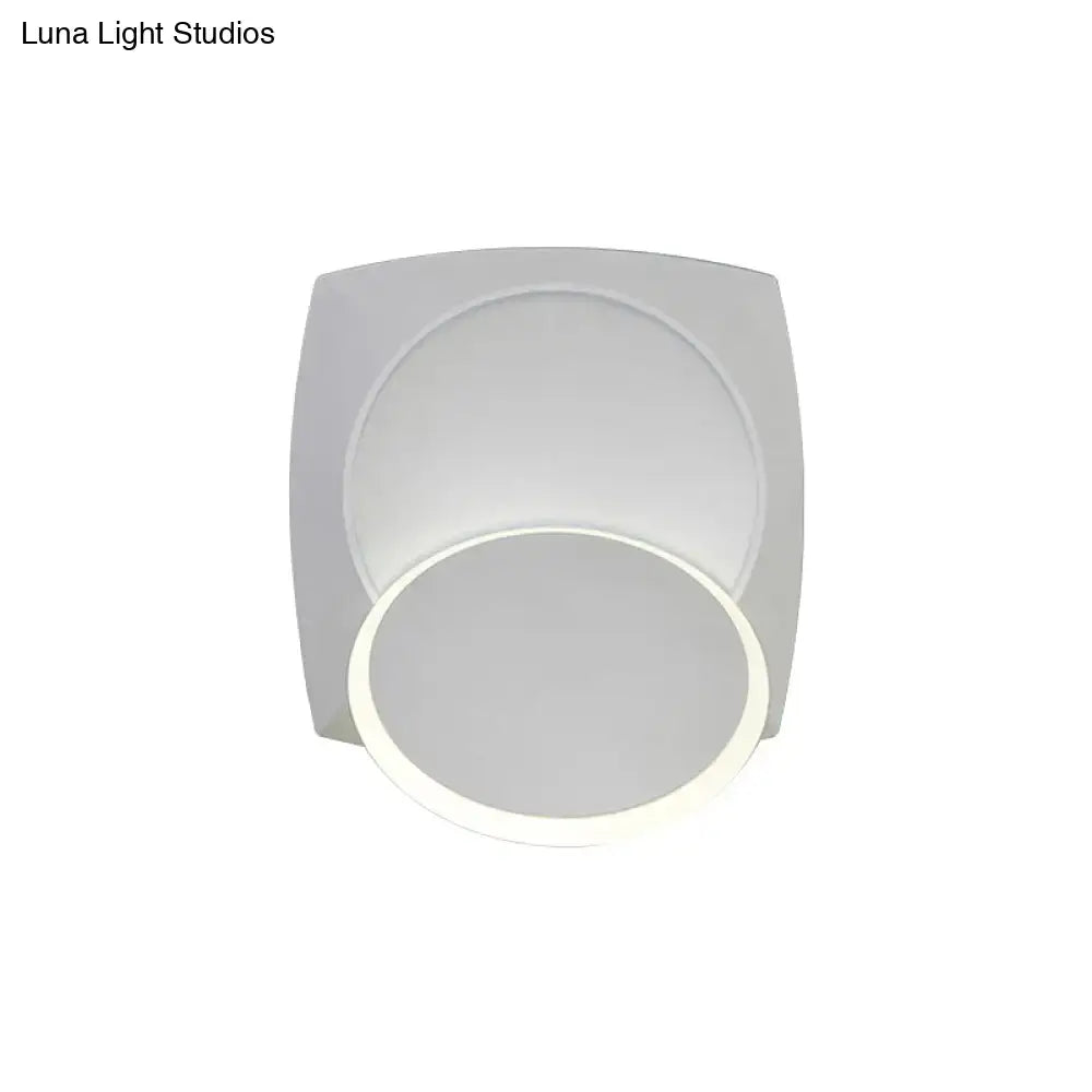 Modern black rotatable led wall sconce with a white square base and circular softly glowing light fixture for bedroom use