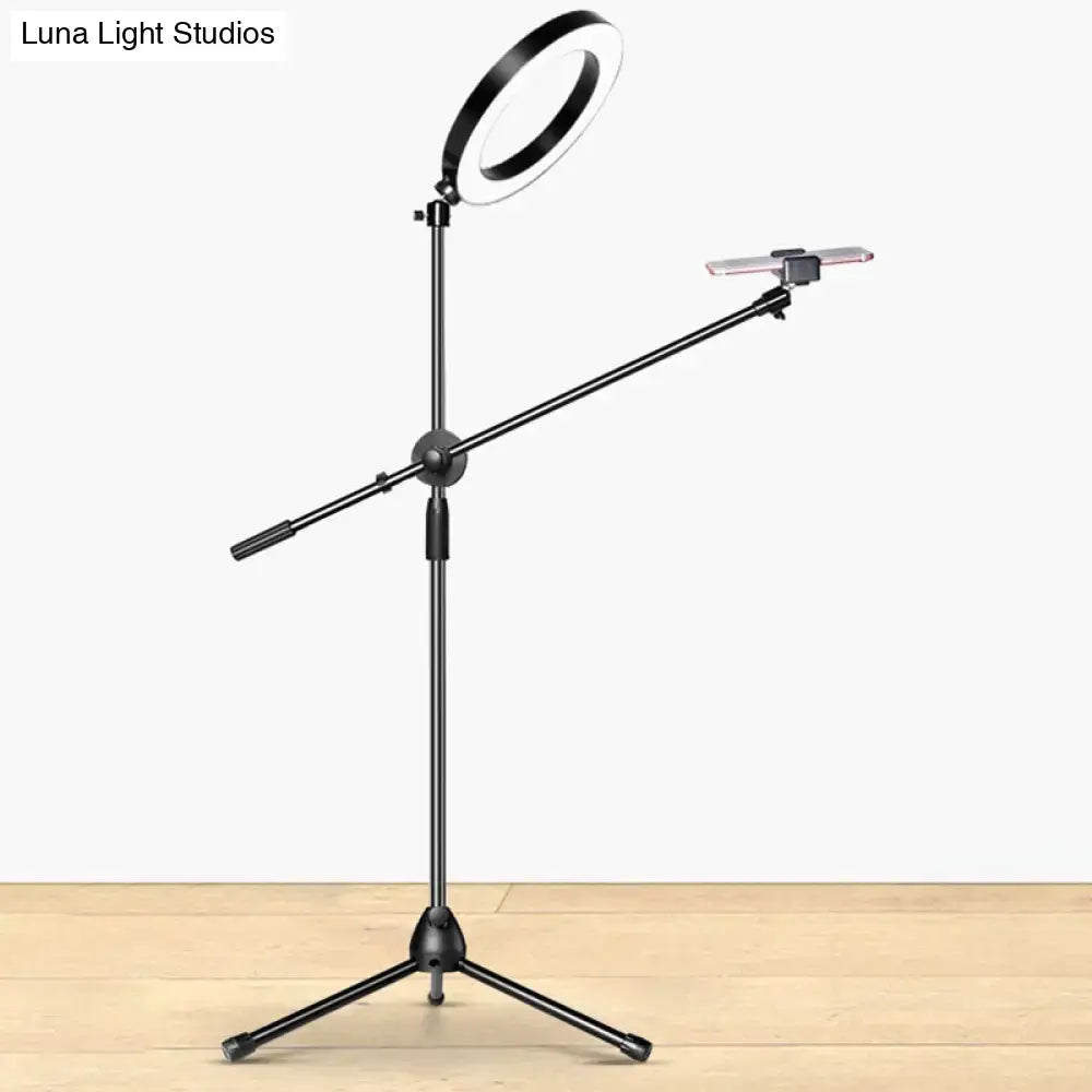 Black round led vanity lamp mounted on adjustable stand with phone clamp for bedroom lighting use