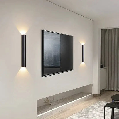 Modern black and silver led wall lamp featuring cylindrical design with warm up and down light sources for bedrooms