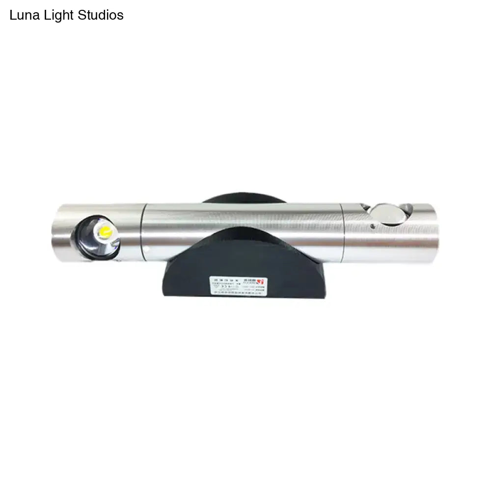 Silver cylindrical led light fixture with sleek metallic finish and black base providing warm white lighting for living room
