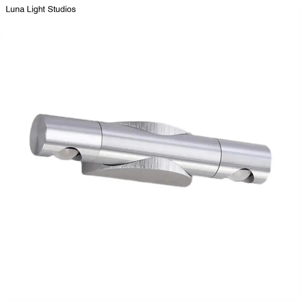 Silver metallic wall-mounted light fixture with two cylindrical arms and warm white lighting for living room use