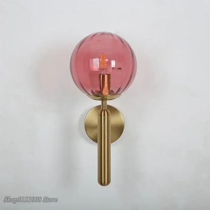 Modern black smoked glass ball led wall lamp with translucent pink decorbites glass ball and polished brass stem and backplate