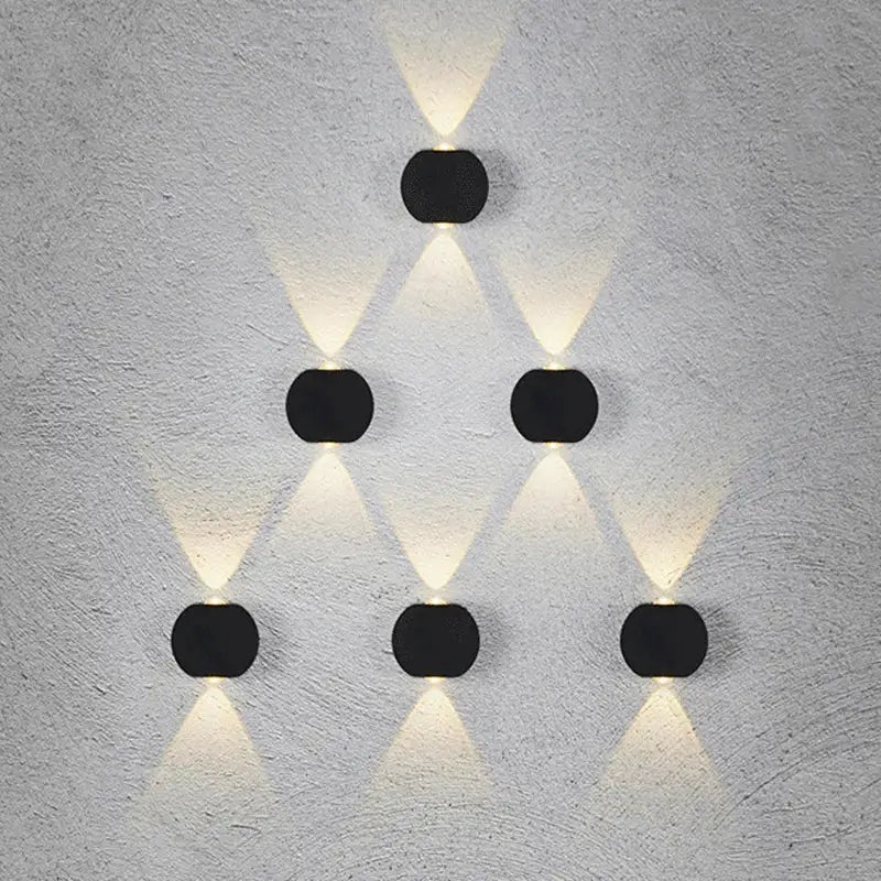 Modern black square led wall light garden sconce with six circular black led wall lights in a triangular pattern emitting warm white light