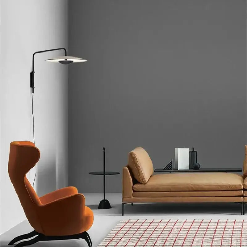 Orange velvet armchair with black metal legs paired with modern black swing arm wall lamp decorbites iron art sconce