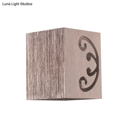 Modern black swirl led wall lamp featuring a brushed metallic cube with elegant scrollwork cutout for bedroom lighting