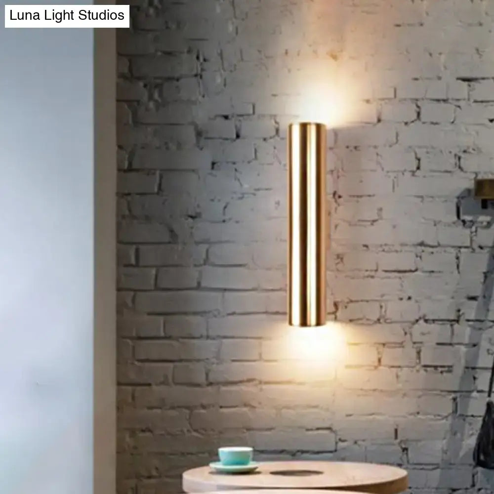 A sleek cylindrical brass wall mounted bedside lamp with modern design compatible with e26 e27 bulbs