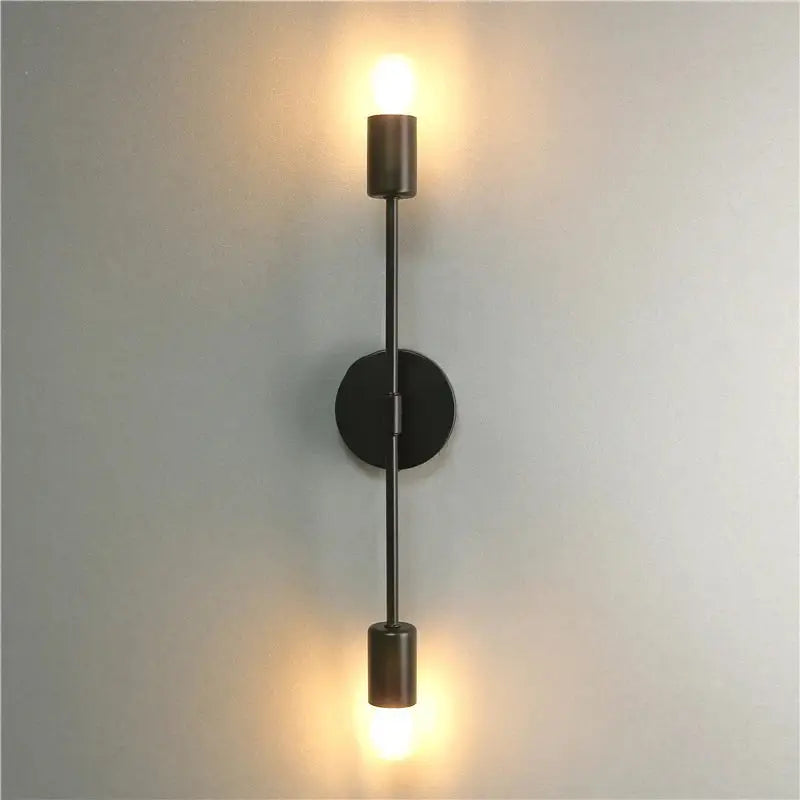 Modern black metal two arm led wall lamp with cylindrical fixtures and circular base for bedroom vanity lighting