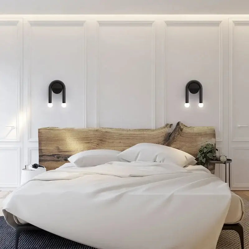 Modern black u-shaped led wall lamp with spherical bulbs mounted above a rustic natural wood headboard decorbites led wall lamp
