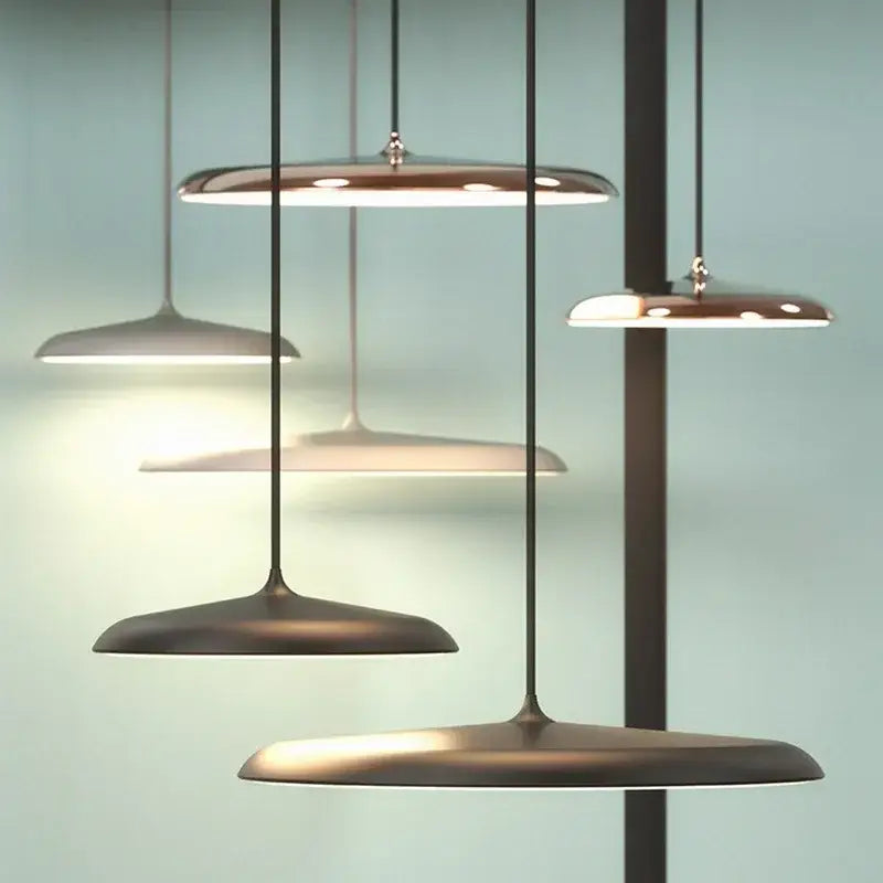 Modern black ufo pendant light with bronze finish disc-shaped shades and minimalist design as dining room light source